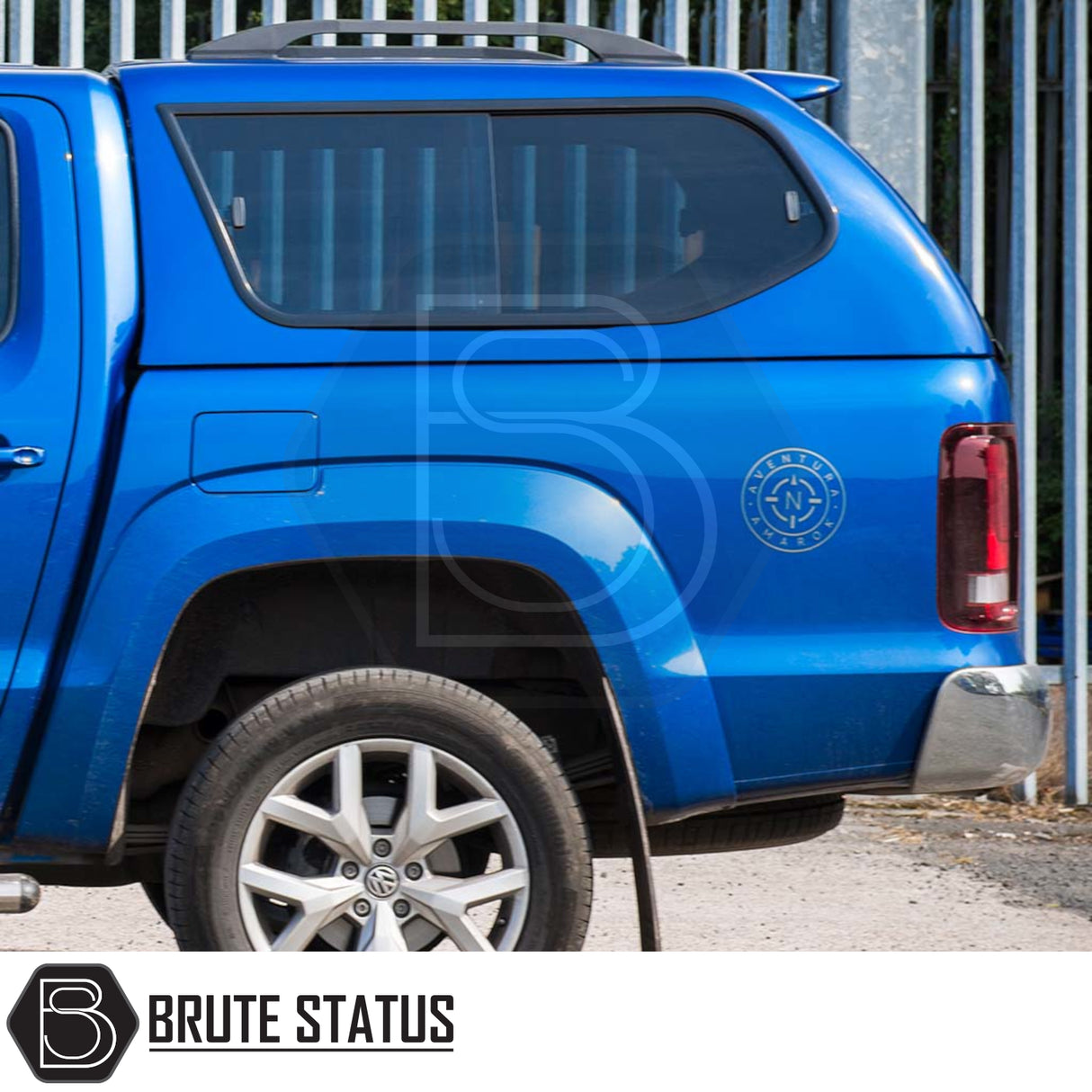 Rear view of blue Volkswagen Amarok with Truckman GLS hardtop canopy, featuring heated rear window, remote locking, and Aventura compass badge.