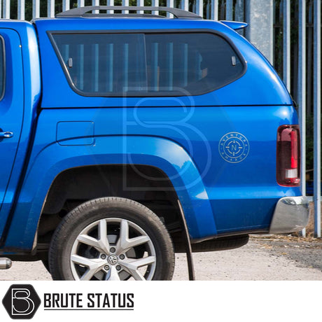 Rear view of blue Volkswagen Amarok with Truckman GLS hardtop canopy, featuring heated rear window, remote locking, and Aventura compass badge.