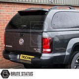 Rear view of a dark grey Volkswagen Amarok with a Truckman Grand Hardtop Canopy, featuring remote locking, tinted windows, and Brute Status branding.