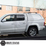 Volkswagen Amarok 2010-2022 Truckman L-Series Hardtop Canopy on silver pickup, enhancing bed security and storage, parked by commercial building, marked with “Brute Status.”