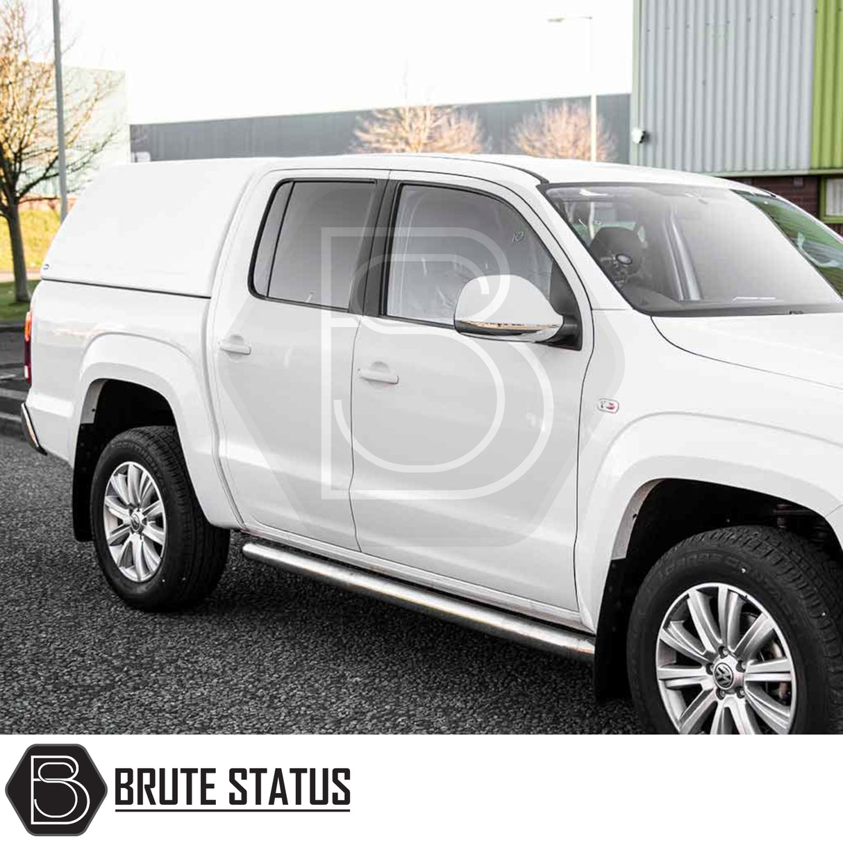 Volkswagen Amarok with Truckman RS Hardtop Canopy featuring solid rear window, remote locking, alloy wheels, and stainless-steel side-step bar, shown in an industrial setting.