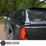 Volkswagen Amarok 2023+ Truckman Grand Hardtop Canopy with remote locking, shown on a black 4x4 in a wooded setting, features pop-out windows and sleek design.