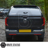 Volkswagen Amarok 2023+ Truckman Grand Hardtop Canopy with remote locking, featuring tinted windows and chrome-trimmed bumper, parked on a forest track.